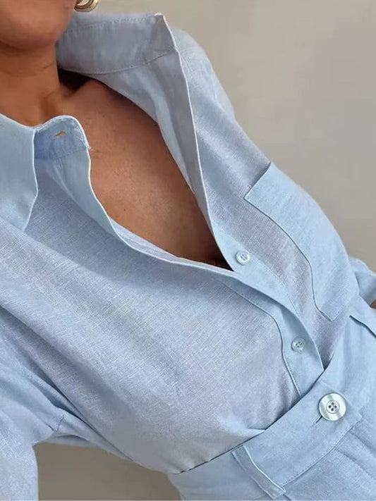 Modelo aproximada mostrando detalhes da camisa manga longa em linho azul com gola de colarinho aberta e fechamento em botões Moda Origem