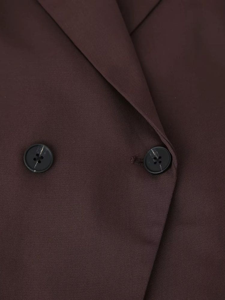 Detalhe aproximado da parte frontal do blazer de alfaiataria marrom com abotoamento duplo de alta qualidade da Moda Origem