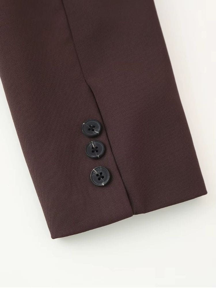Close no punho da manga do blazer alongado marrom, destacando o detalhe dos botões aplicados pela marca Moda Origem