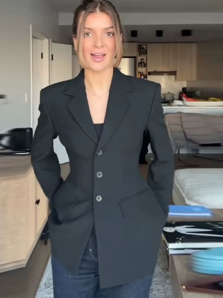 Modelo vestindo blazer feminino alfaiataria acinturado preto de corpo inteiro, silhueta ampulheta estruturada Moda Origem.