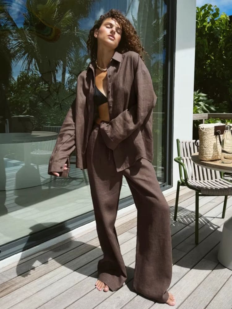 Modelo de frente exibindo o look monocromático completo com o conjunto de alfaiataria em linho marrom da nova coleção Moda Origem