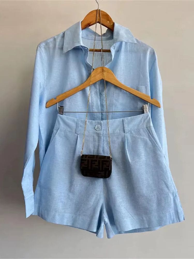 Conjunto azul em linho fino pendurado no cabide com uma mini bolsa de alça longa combinando com a peça na Moda Origem