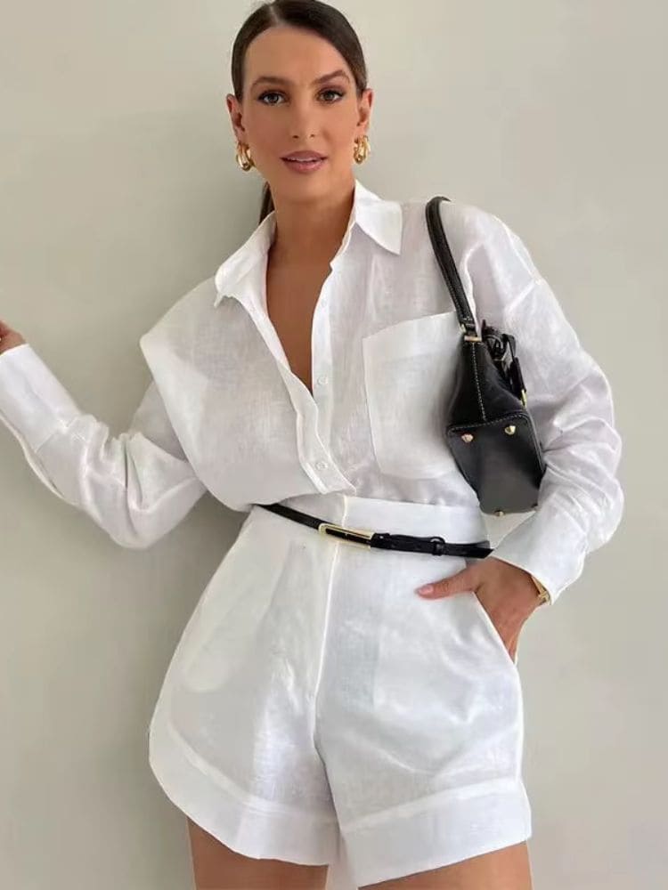 Modelo de frente usando o conjunto feminino em linho branco completo com a mão no bolso lateral do short Moda Origem