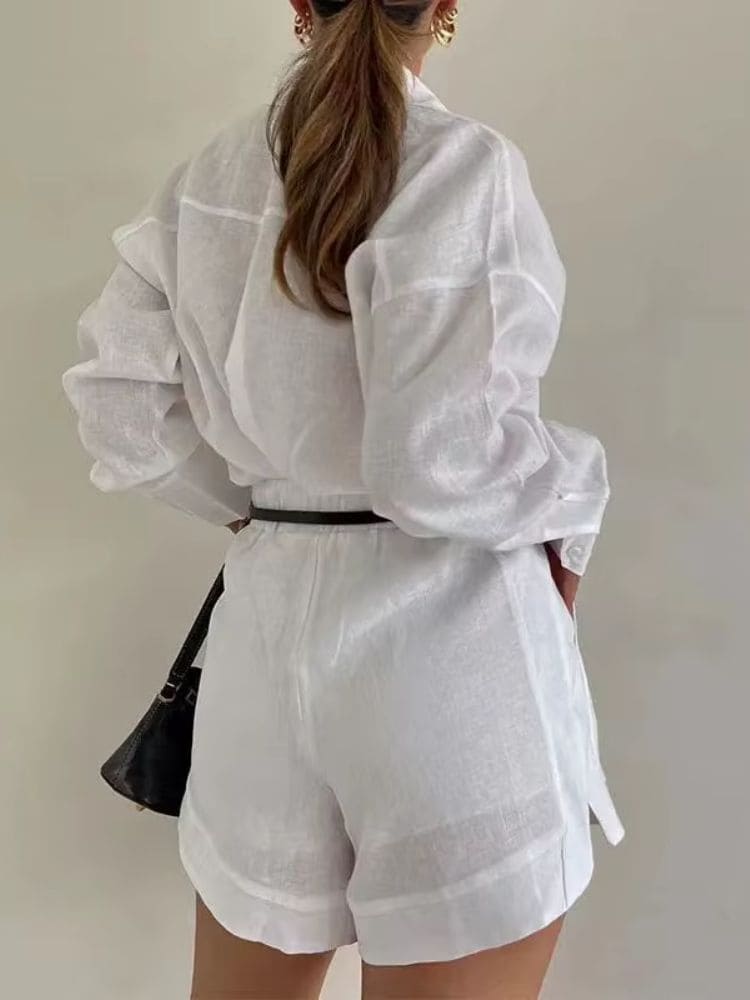 Modelo de costas exibindo o caimento solto e os detalhes estruturados do conjunto feminino em linho branco da Moda Origem