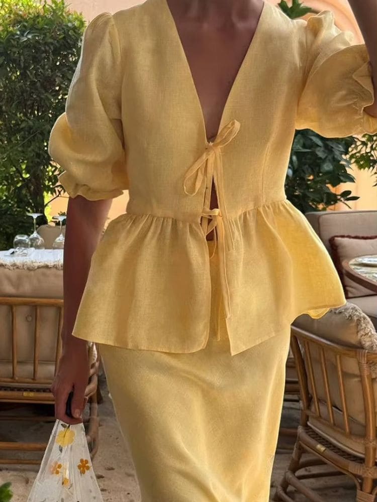 Close no decote em V com amarração por laços e detalhe peplum do conjunto amarelo Moda Origem