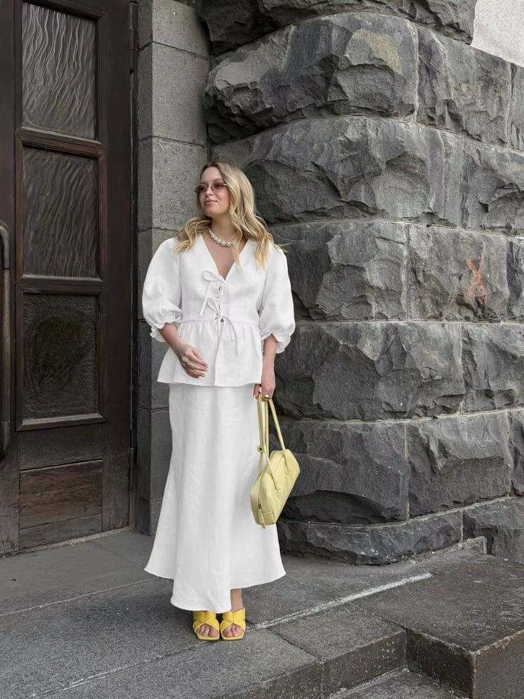 Modelo exibe caimento elegante do conjunto de algodão com saia longa branca da loja Moda Origem