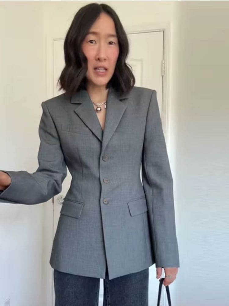 Modelo usando blazer cinza grafite alongado com silhueta ampulheta e gola lapela Moda Origem