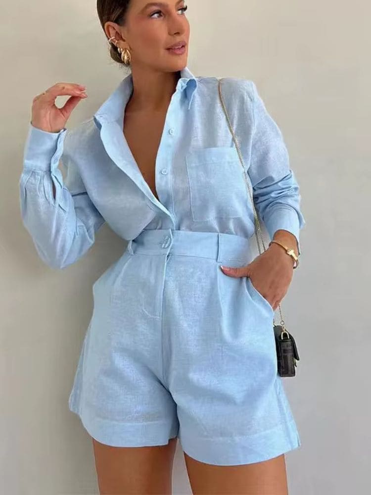 Modelo posando de frente com o conjunto de alfaiataria azul em linho e acessórios modernos da nova coleção Moda Origem